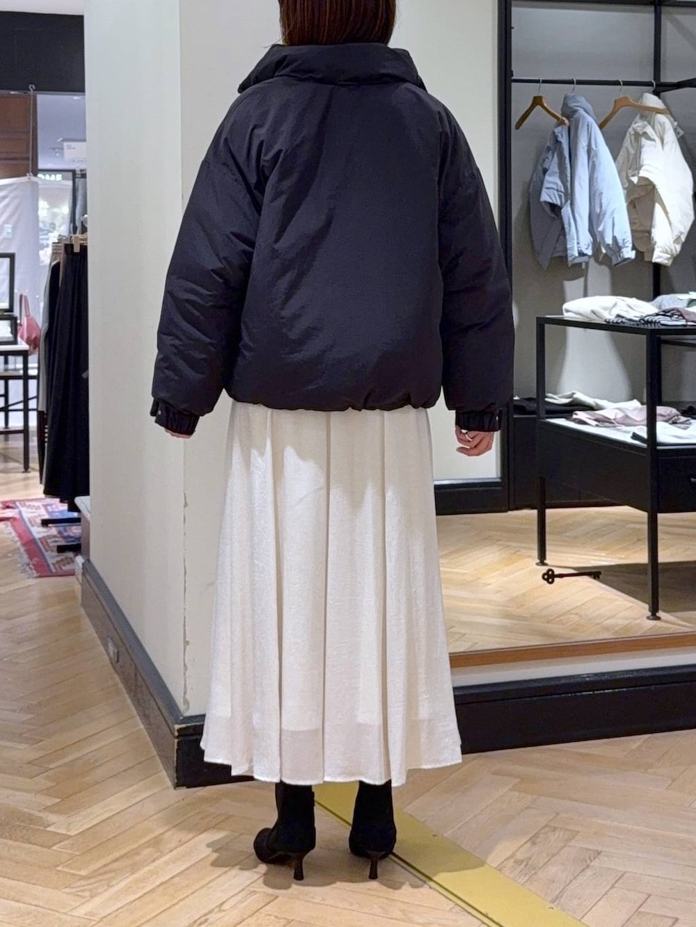 ブラウン系のニット/セーター、ブラック系のブルゾン、ブラック系のブーツを着用したレディースの秋コーディネートの5枚目の写真