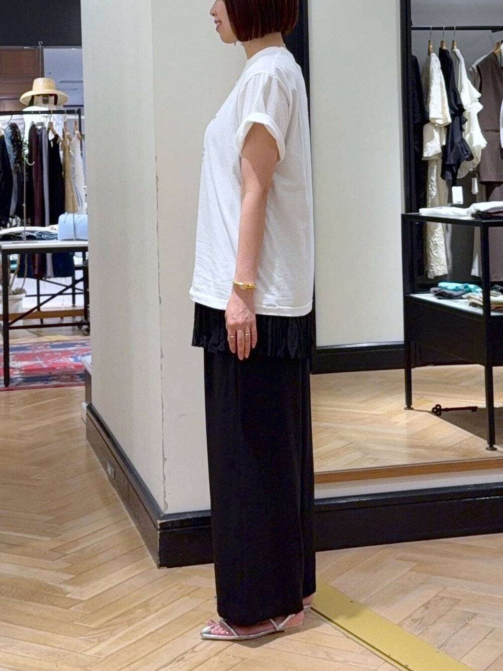 ホワイト系のTシャツ/カットソー、シルバー系のサンダル、ブラック系のハンドバッグを着用したレディースの夏コーディネートの2枚目の写真