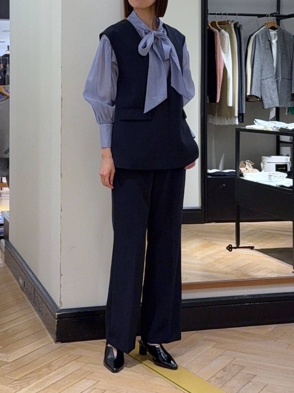 ブラック系のショルダーバッグ、ブルー系のシャツ/ブラウス、ブルー系のスーツセットを着用したレディースの冬コーディネートの2枚目の写真