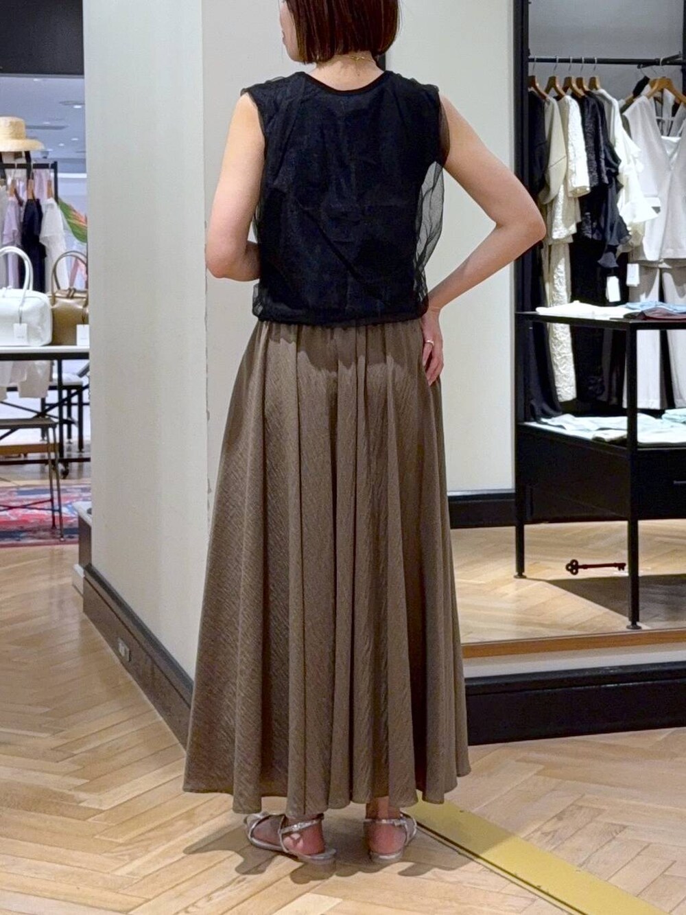 シルバー系のサンダル、ブラック系のニット/セーター、グリーン系のスカートを着用したレディースの夏コーディネートの4枚目の写真