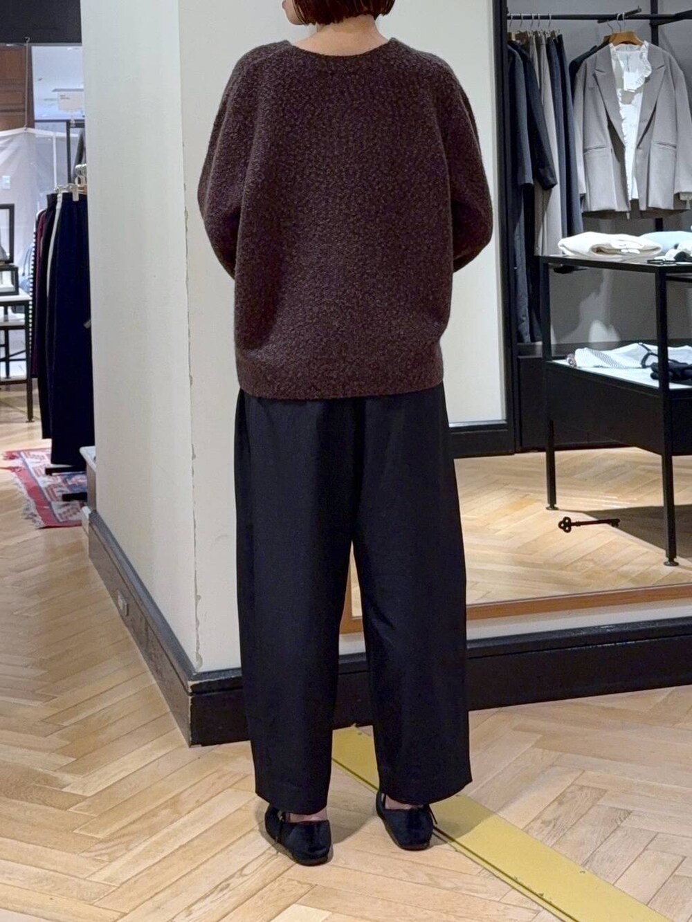 ブラック系のスラックス、ブラウン系のカーディガン/ボレロ、ブラック系のショルダーバッグを着用したレディースの秋コーディネートの3枚目の写真