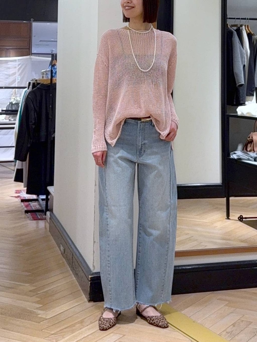 ブルー系のデニムパンツ、ブラウン系のパンプス、ピンク系のニット/セーターを着用したレディースの春コーディネートの4枚目の写真