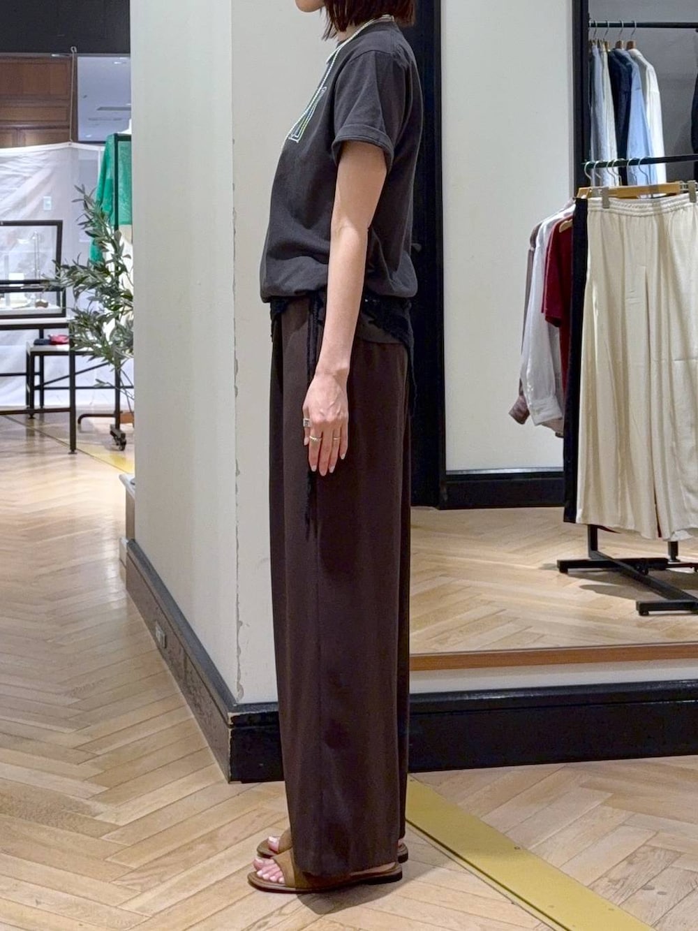 ブラウン系のスラックス、ブラック系のショルダーバッグ、グレー系のTシャツ/カットソーを着用したレディースの夏コーディネートの3枚目の写真