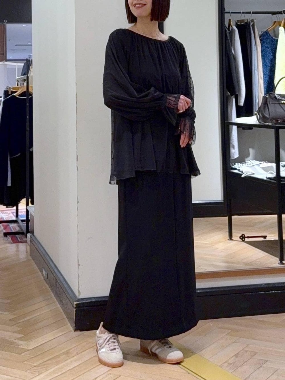 グリーン系のトートバッグ、ベージュ系のスニーカー、ブラック系のシャツ/ブラウスを着用したレディースの春コーディネートの4枚目の写真