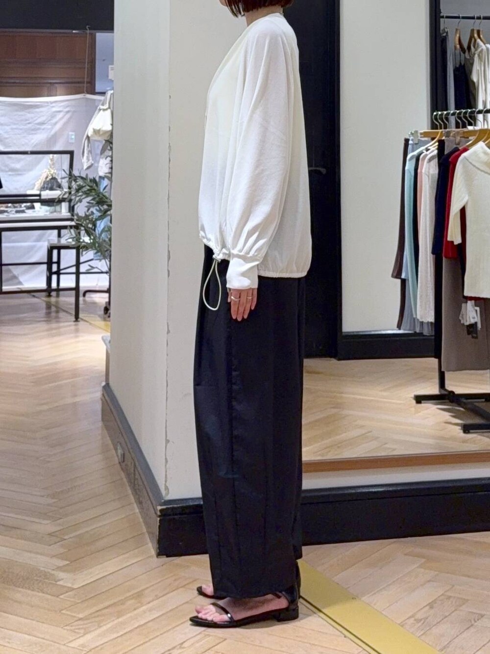 ホワイト系のカーディガン/ボレロ、イエロー系のタンクトップ、ブラック系のショルダーバッグを着用したレディースの春コーディネートの3枚目の写真