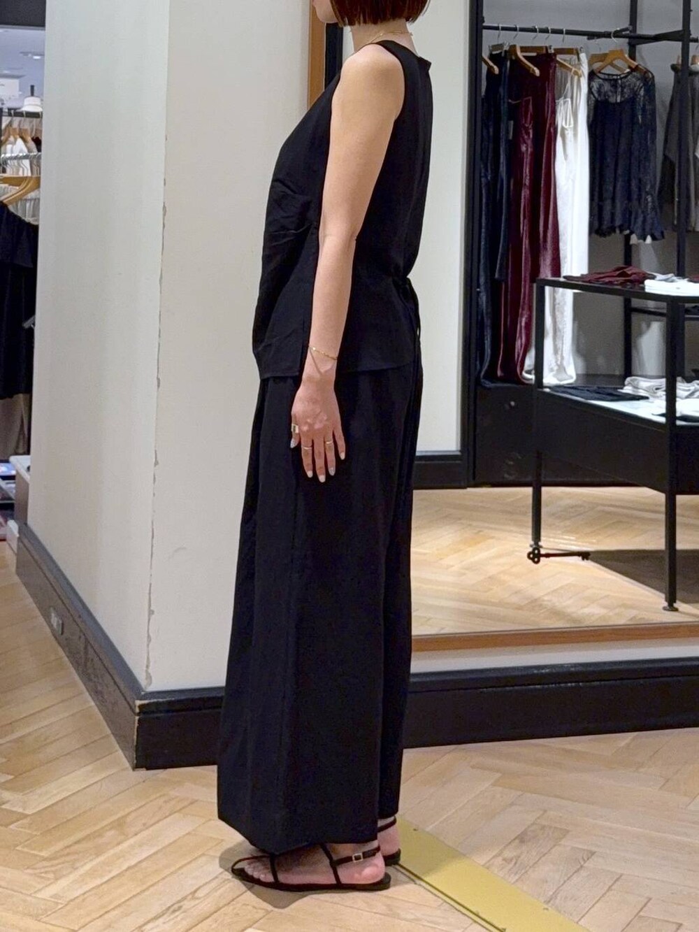 ブラウン系のサンダル、ベージュ系のショルダーバッグ、ブラック系のパンツドレスを着用したレディースの夏コーディネートの2枚目の写真