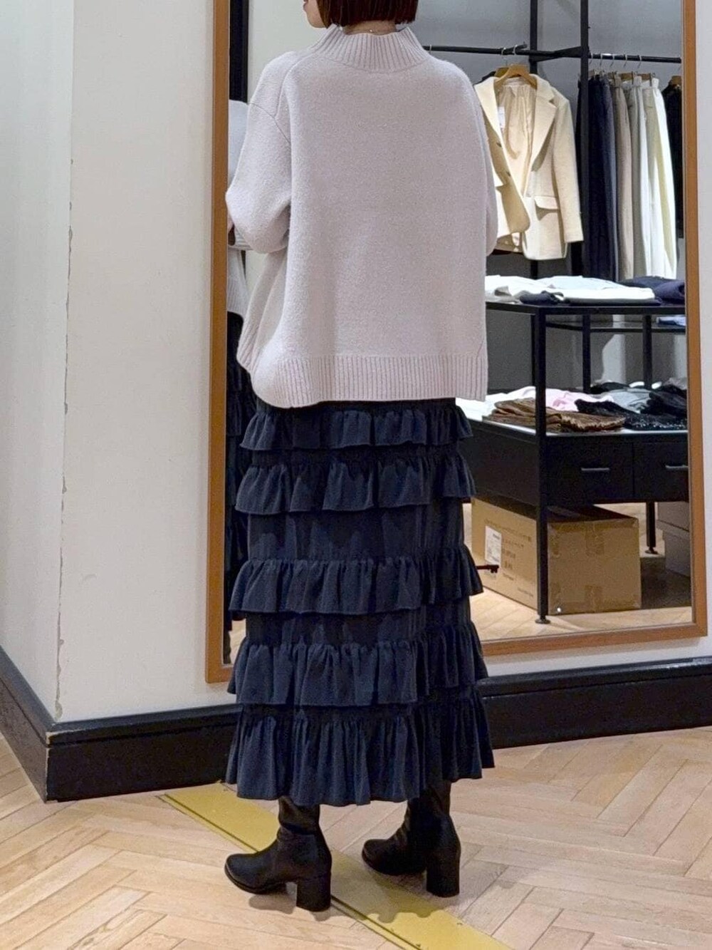 ブラック系のブーツ、グレー系のニット/セーター、ブラック系のスカートを着用したレディースの冬コーディネートの5枚目の写真