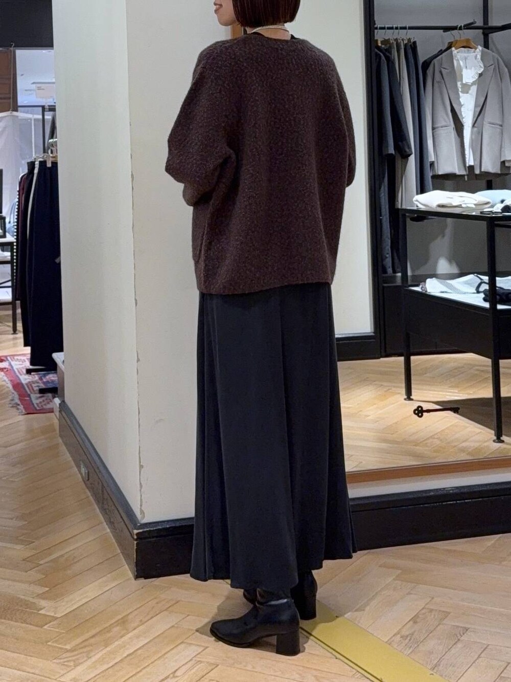 ブラック系のブーツ、ブラウン系のカーディガン/ボレロ、ブラック系のスカートを着用したレディースの秋コーディネートの4枚目の写真