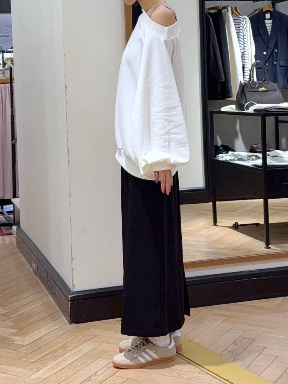 ベージュ系のスニーカー、ブラック系のショルダーバッグ、ホワイト系のスウェットを着用したレディースの冬コーディネートの3枚目の写真