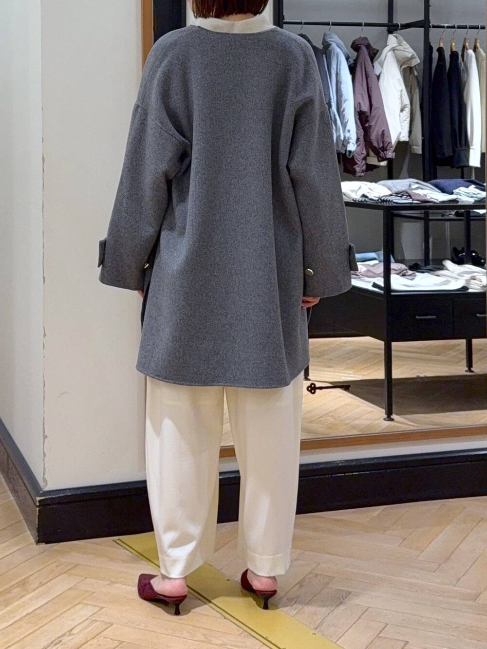 ホワイト系のスラックス、レッド系のパンプス、ブラック系のショルダーバッグを着用したレディースの秋コーディネートの6枚目の写真