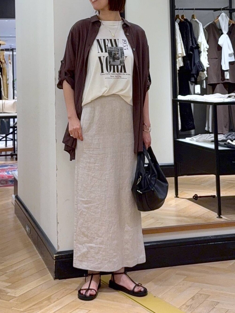 ブラック系のハンドバッグ、ホワイト系のTシャツ/カットソー、ブラウン系のシャツ/ブラウスを着用したレディースの夏コーディネートの5枚目の写真