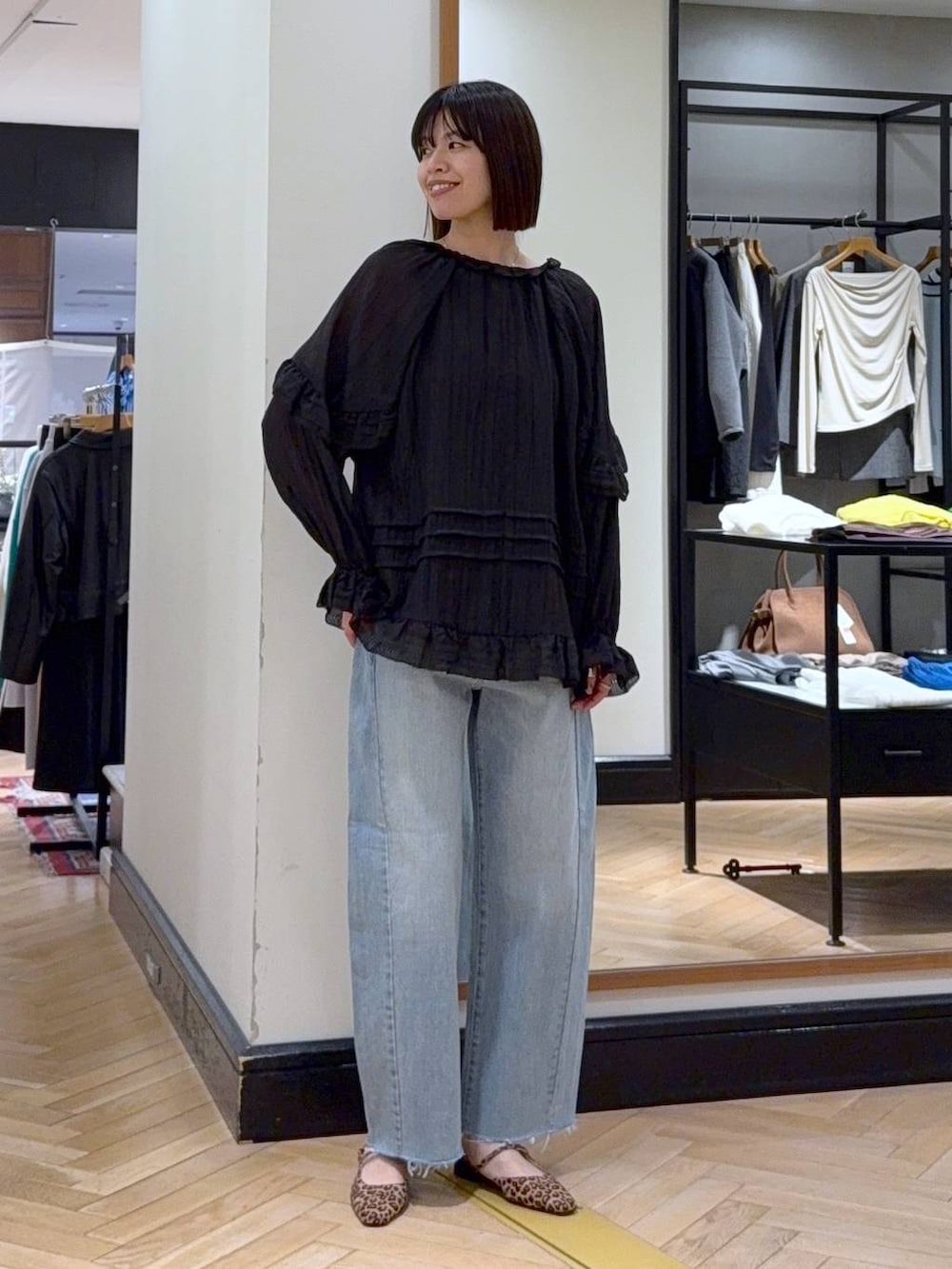 ブルー系のデニムパンツ、ブラック系のシャツ/ブラウス、ブラウン系のパンプスを着用したレディースの春コーディネートの2枚目の写真