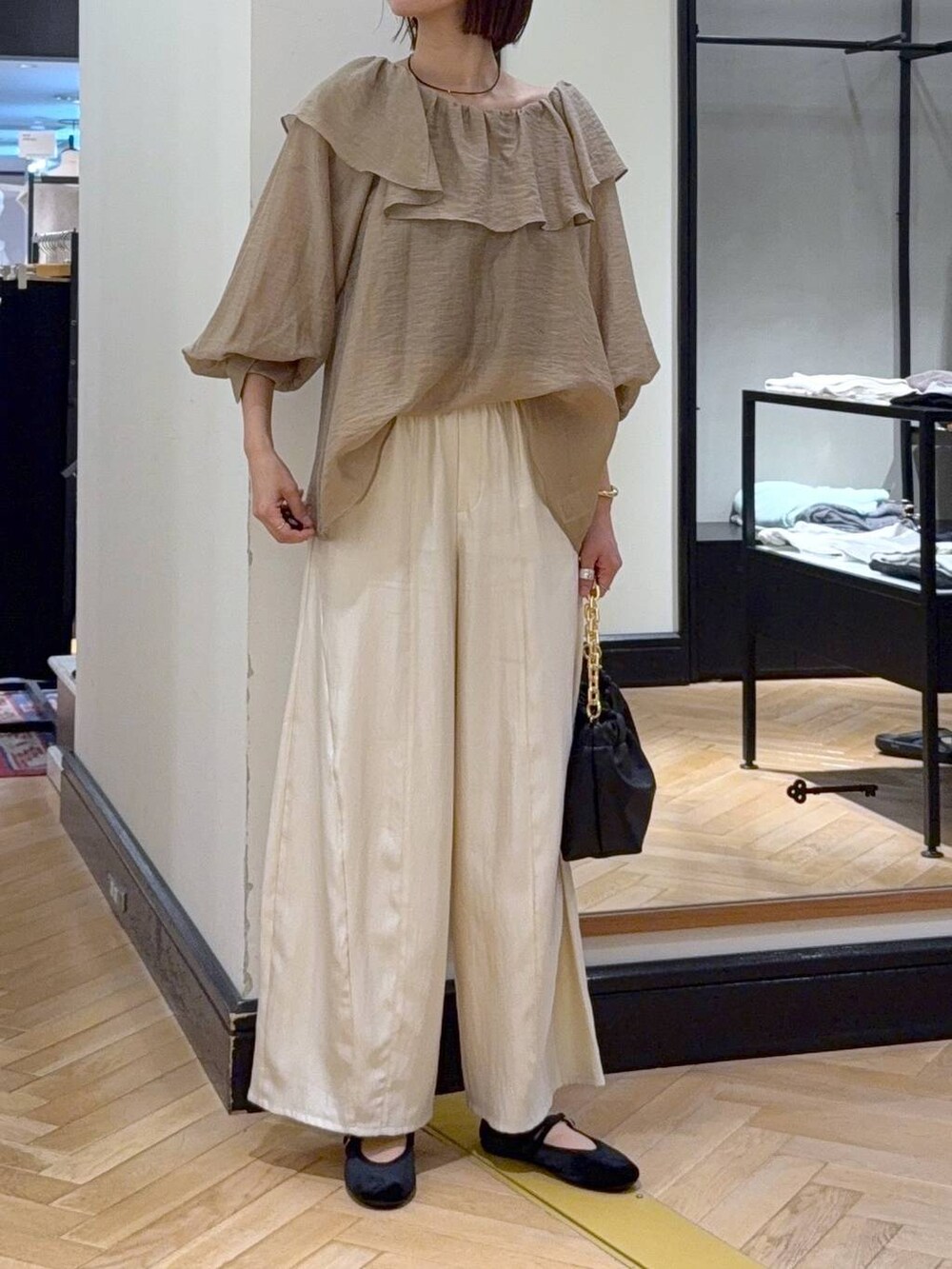 ホワイト系のその他パンツ、ブラック系のバレエシューズ、ブラック系のショルダーバッグを着用したレディースの秋コーディネートの2枚目の写真