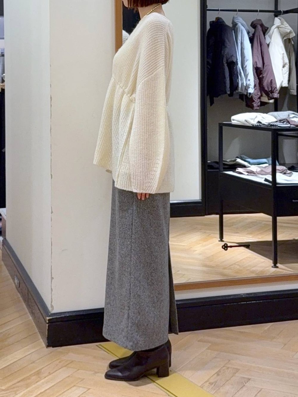 ブラウン系のブーツ、ブラック系のショルダーバッグ、ブラック系のスカートを着用したレディースの秋コーディネートの3枚目の写真