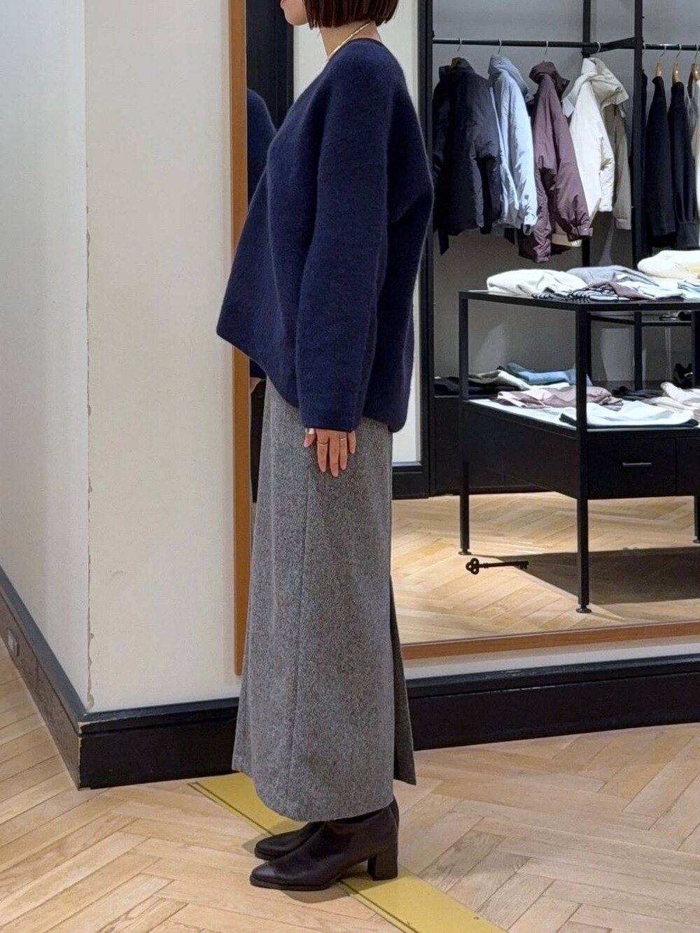 ブルー系のカーディガン/ボレロ、ホワイト系のTシャツ/カットソー、ブラック系のブーツを着用したレディースの秋コーディネートの3枚目の写真