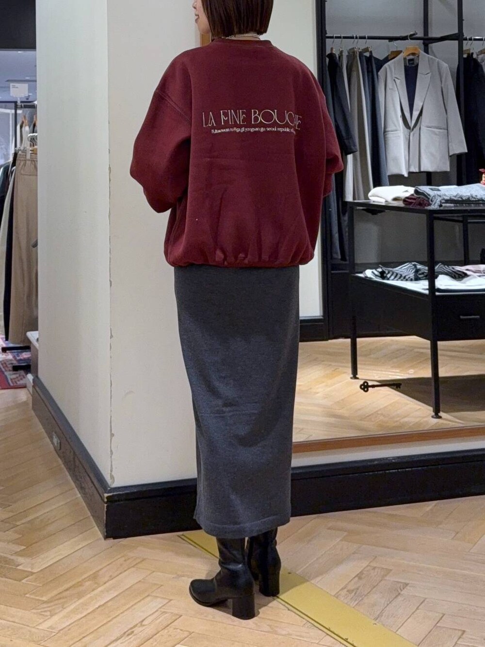 ブラック系のブーツ、ブラック系のショルダーバッグ、グレー系のワンピースを着用したレディースの秋コーディネートの3枚目の写真