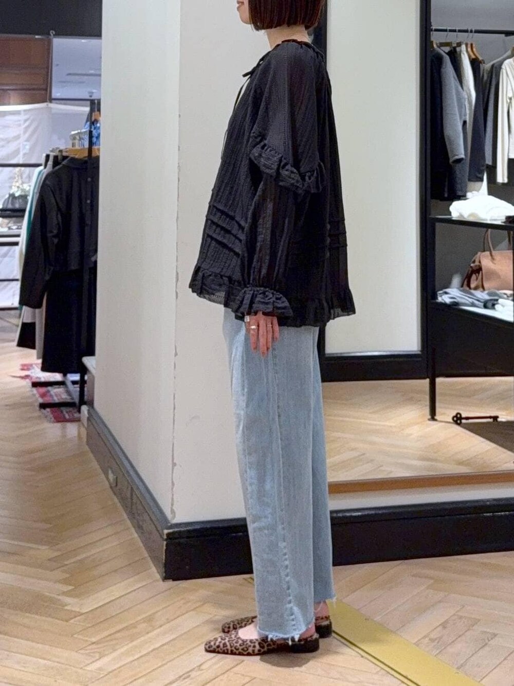 ブルー系のデニムパンツ、ブラック系のシャツ/ブラウス、ブラウン系のパンプスを着用したレディースの春コーディネートの3枚目の写真