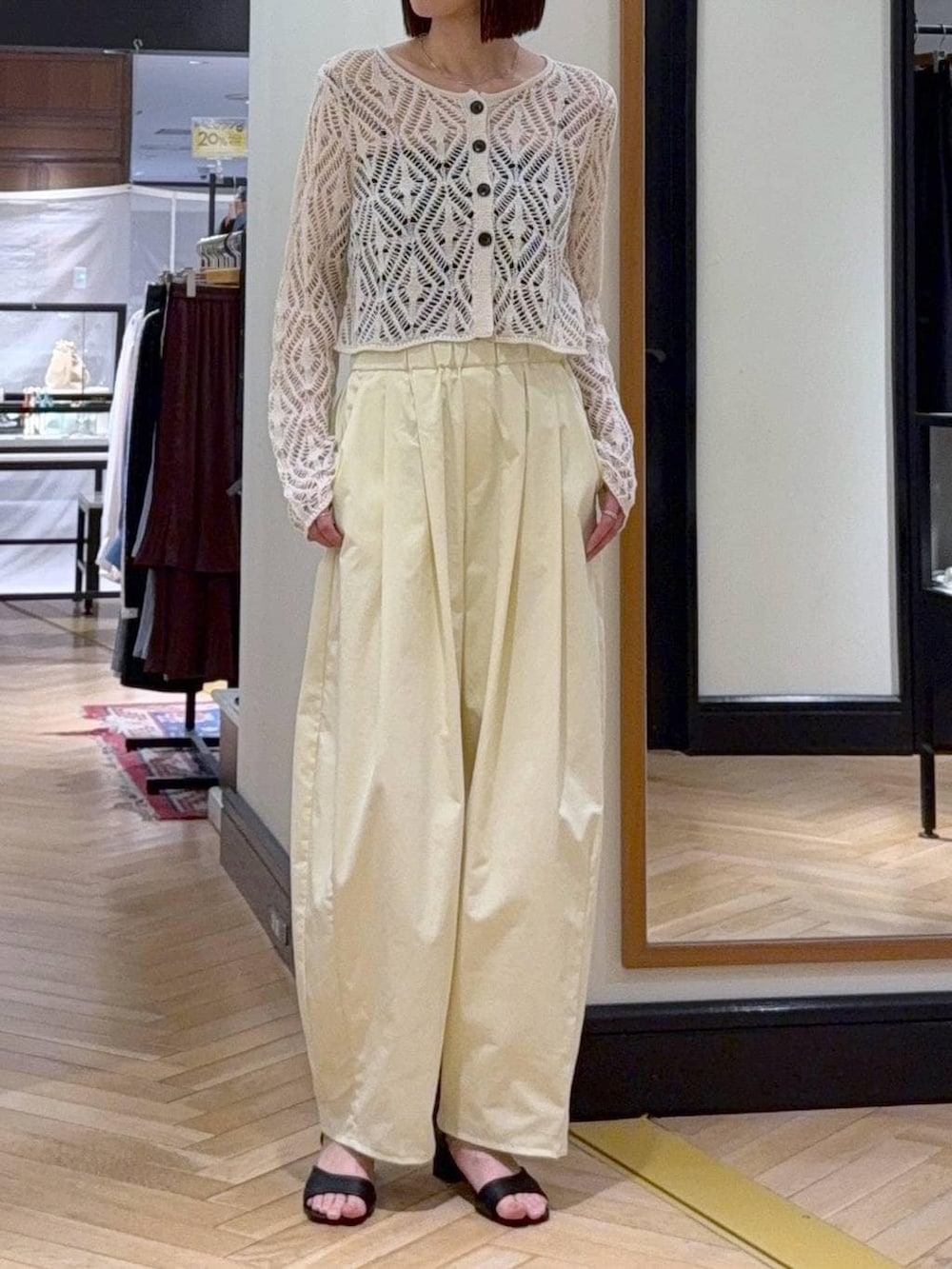 ホワイト系のショルダーバッグ、ホワイト系のカーディガン/ボレロ、ブラック系のサンダルを着用したレディースの春コーディネートの2枚目の写真