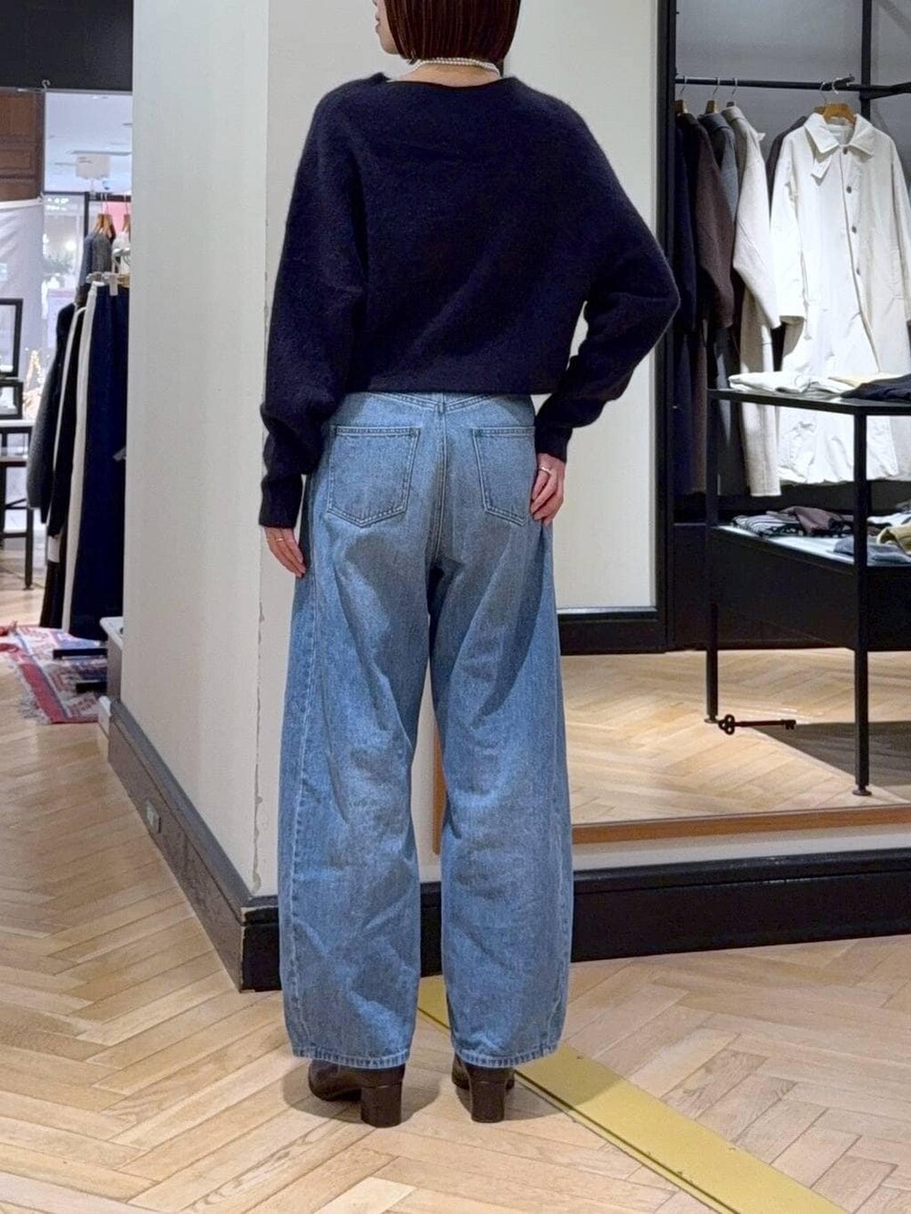 ブルー系のニット/セーター、ブルー系のデニムパンツ、ブラウン系のブーツを着用したレディースの秋コーディネートの4枚目の写真