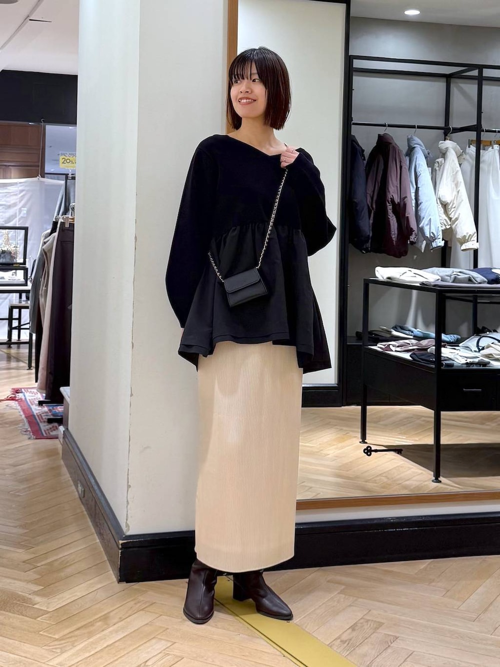 ブラウン系のブーツ、ホワイト系のスカート、ブラック系のニット/セーターを着用したレディースの秋コーディネートの5枚目の写真