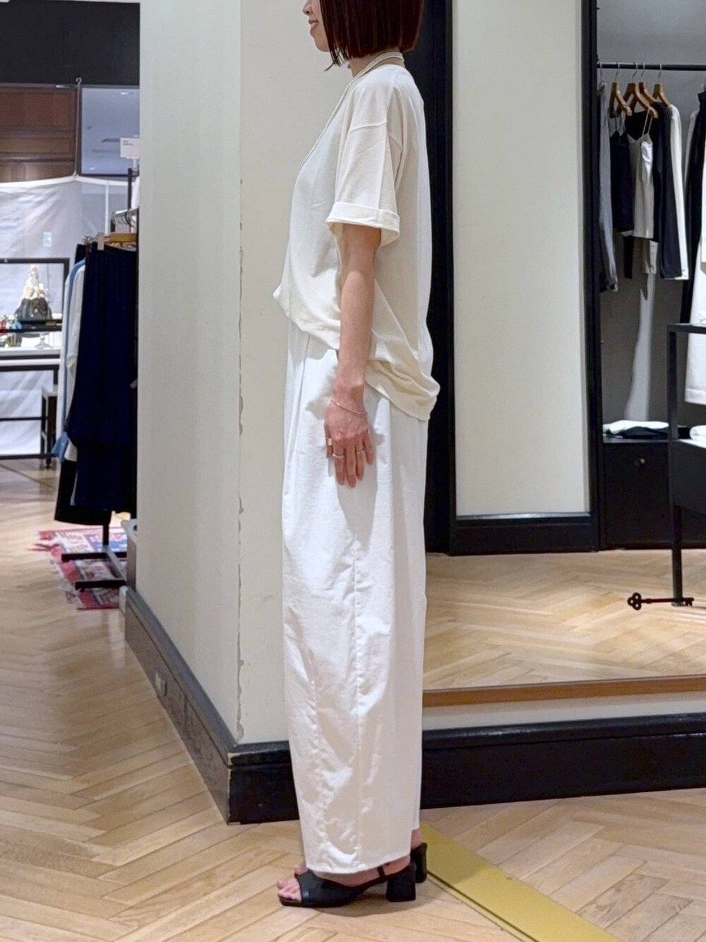 ブラック系のショルダーバッグ、ブラック系のサンダル、ホワイト系のTシャツ/カットソーを着用したレディースの春コーディネートの3枚目の写真