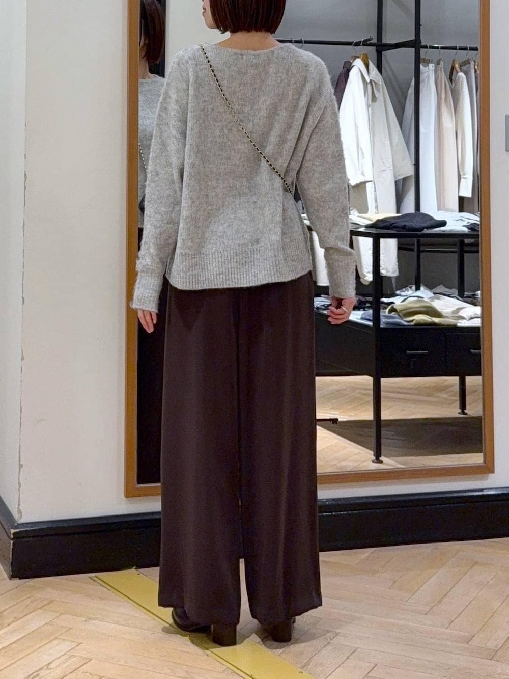 ブラウン系のブーツ、グレー系のニット/セーター、ブラウン系のスラックスを着用したレディースの秋コーディネートの4枚目の写真