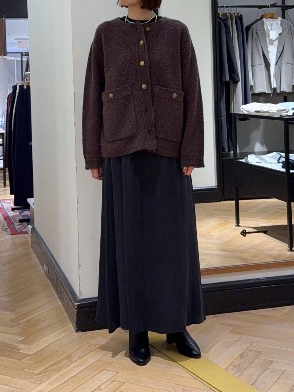 ブラック系のブーツ、ブラウン系のカーディガン/ボレロ、ブラック系のスカートを着用したレディースの秋コーディネートの6枚目の写真