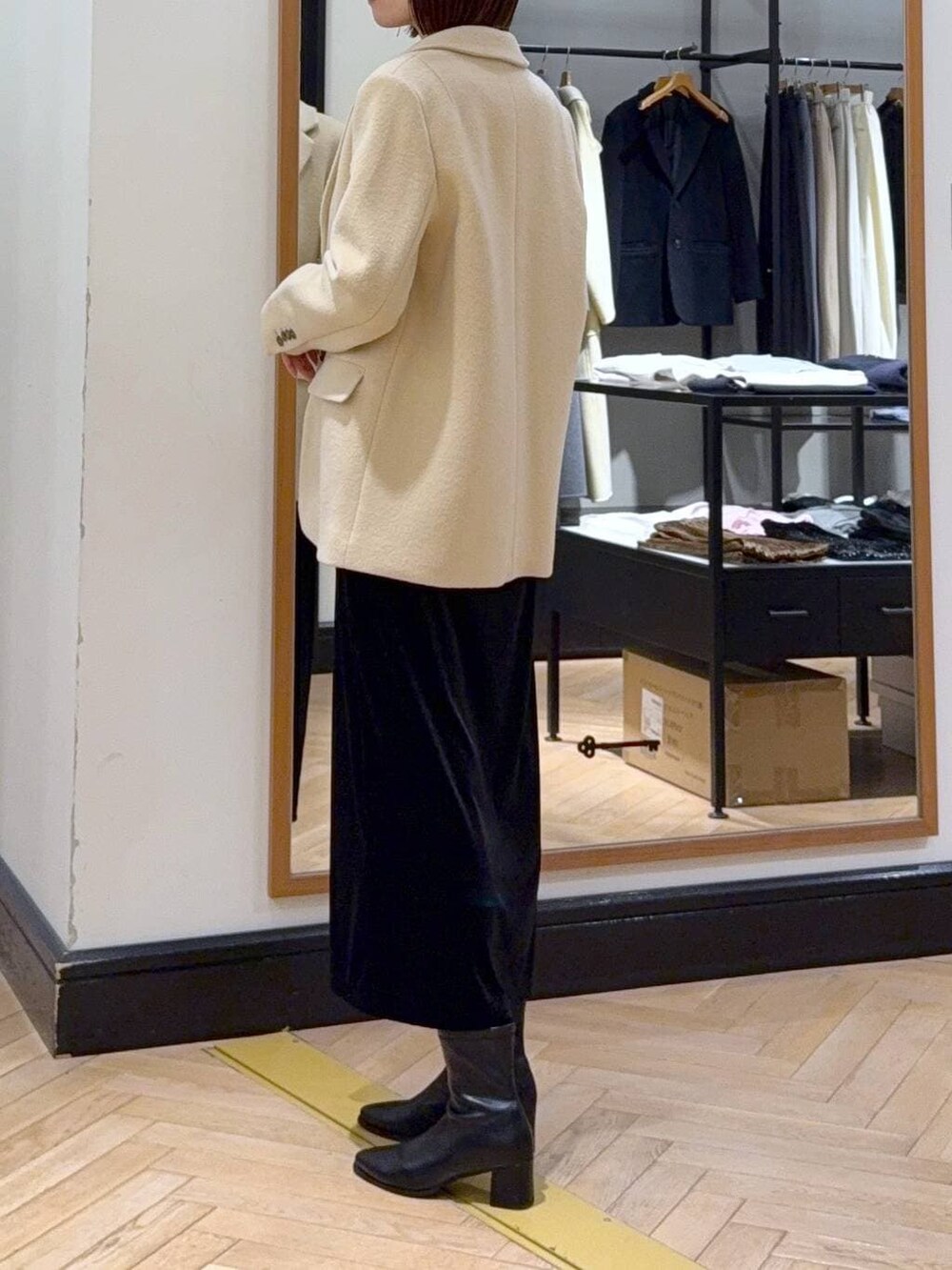 ブラック系のブーツ、ベージュ系のTシャツ/カットソー、ブラック系のショルダーバッグを着用したレディースの冬コーディネートの2枚目の写真