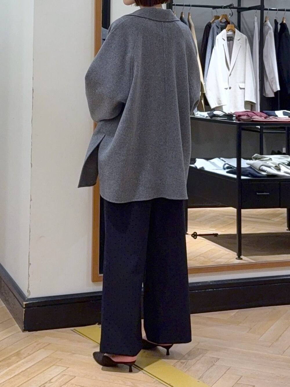 グレー系のその他アウター、ホワイト系のニット/セーター、ブラック系のスラックスを着用したレディースの秋コーディネートの6枚目の写真