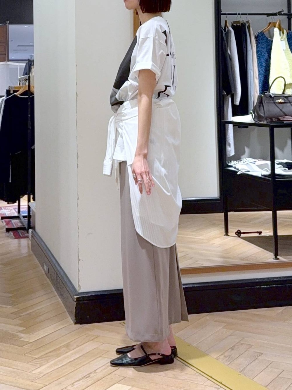 ブラック系のショルダーバッグ、ホワイト系のシャツ/ブラウス、ブラック系のパンプスを着用したレディースの春コーディネートの3枚目の写真