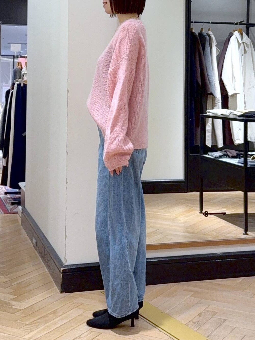 ブルー系のデニムパンツ、ブラック系のショルダーバッグ、ブラック系のブーツを着用したレディースの秋コーディネートの2枚目の写真