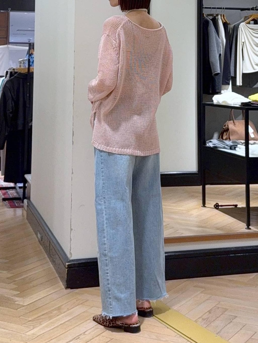 ブルー系のデニムパンツ、ブラウン系のパンプス、ピンク系のニット/セーターを着用したレディースの春コーディネートの3枚目の写真