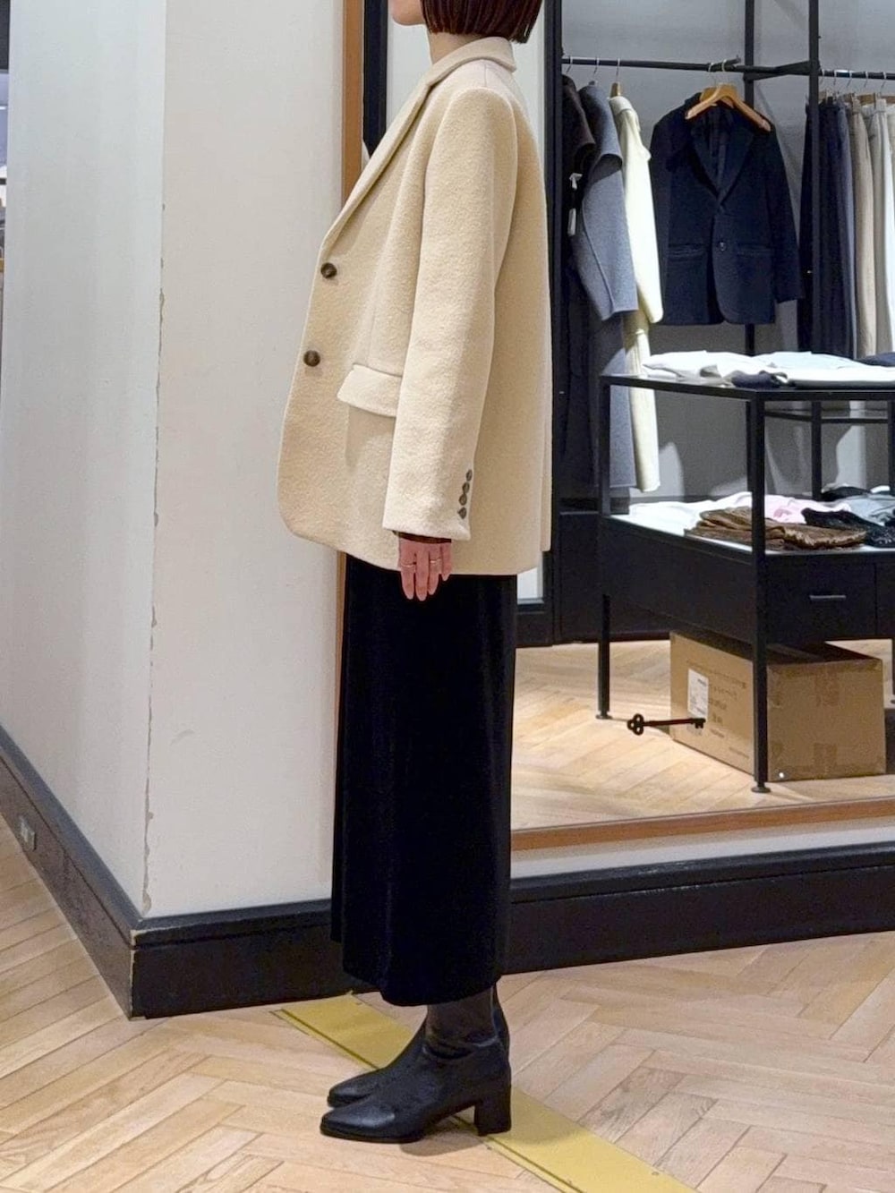 ブラック系のブーツ、ベージュ系のTシャツ/カットソー、ブラック系のショルダーバッグを着用したレディースの冬コーディネートの3枚目の写真