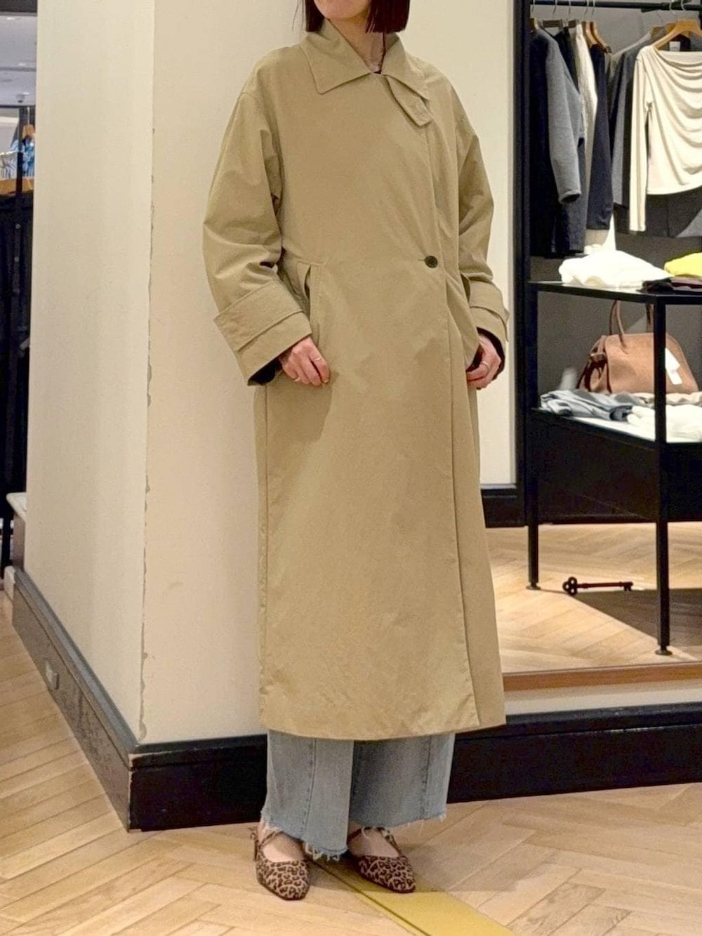 ブルー系のデニムパンツ、ブラウン系のショルダーバッグ、ベージュ系のその他アウターを着用したレディースの春コーディネートの6枚目の写真