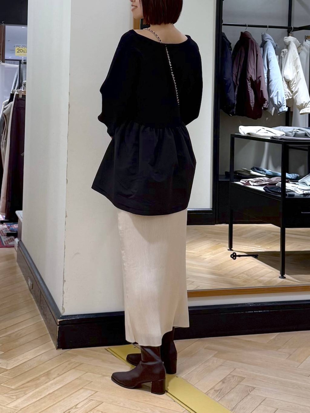 ブラウン系のブーツ、ホワイト系のスカート、ブラック系のニット/セーターを着用したレディースの秋コーディネートの3枚目の写真