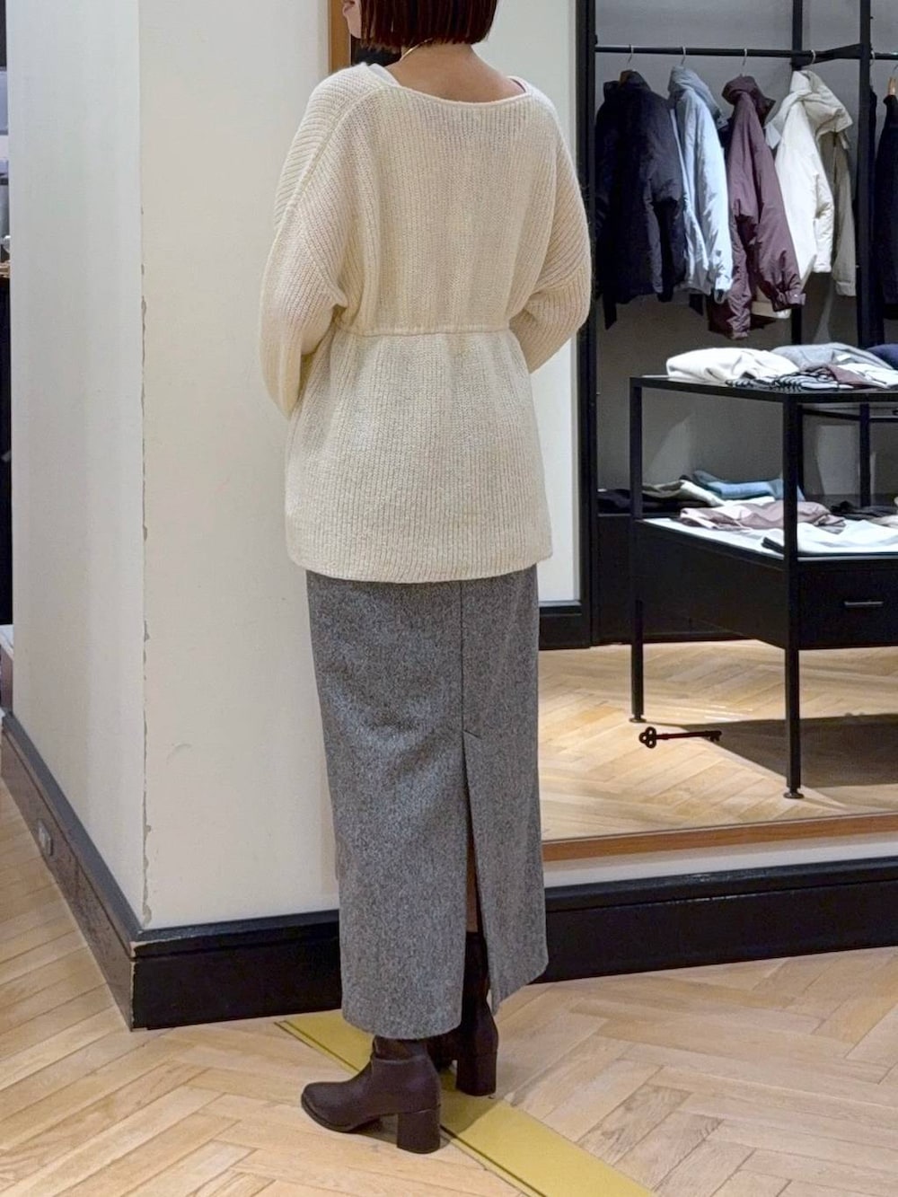 ブラウン系のブーツ、ブラック系のショルダーバッグ、ブラック系のスカートを着用したレディースの秋コーディネートの4枚目の写真