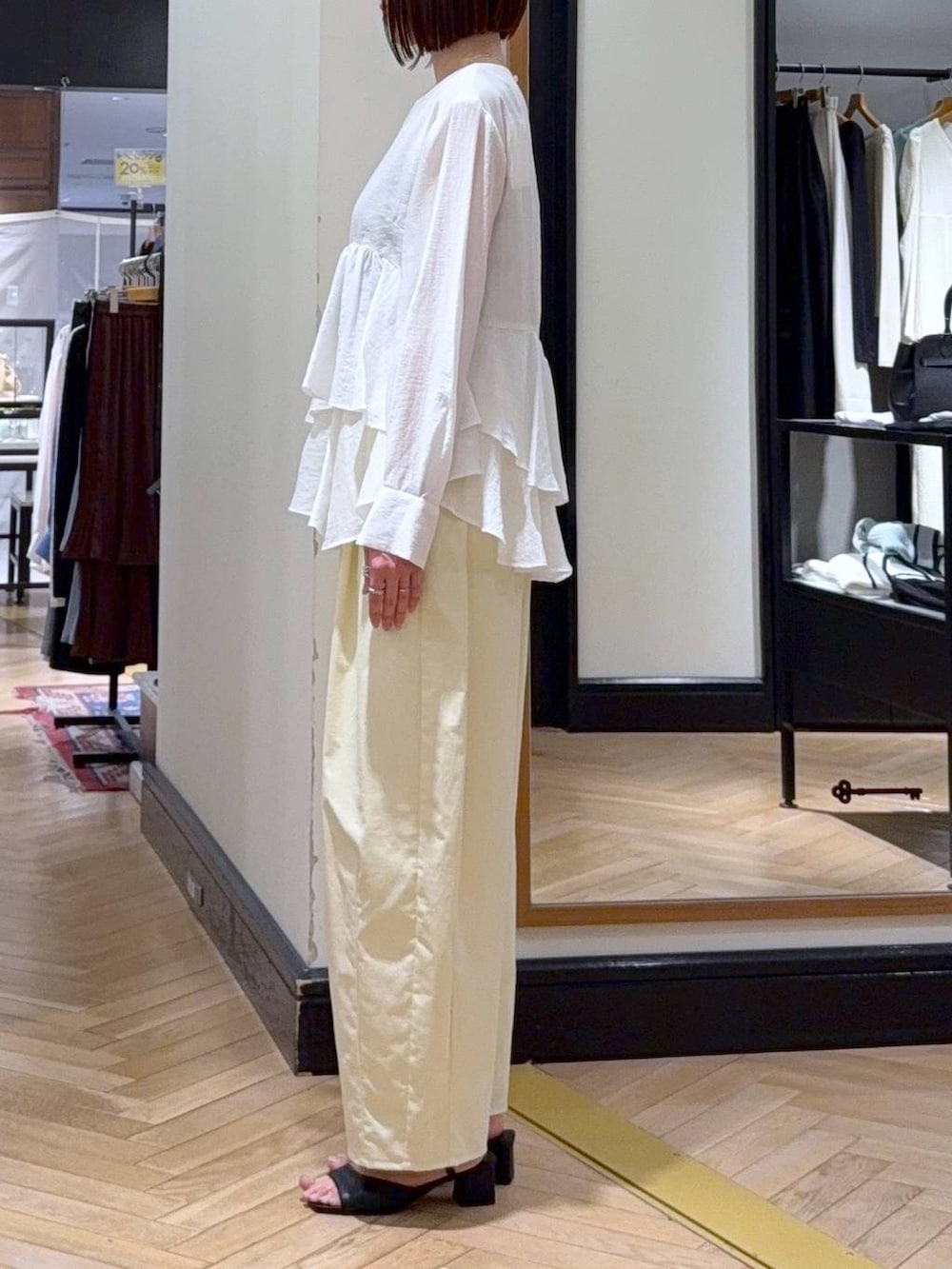 ブラック系のショルダーバッグ、ホワイト系のシャツ/ブラウス、ブラック系のサンダルを着用したレディースの春コーディネートの2枚目の写真