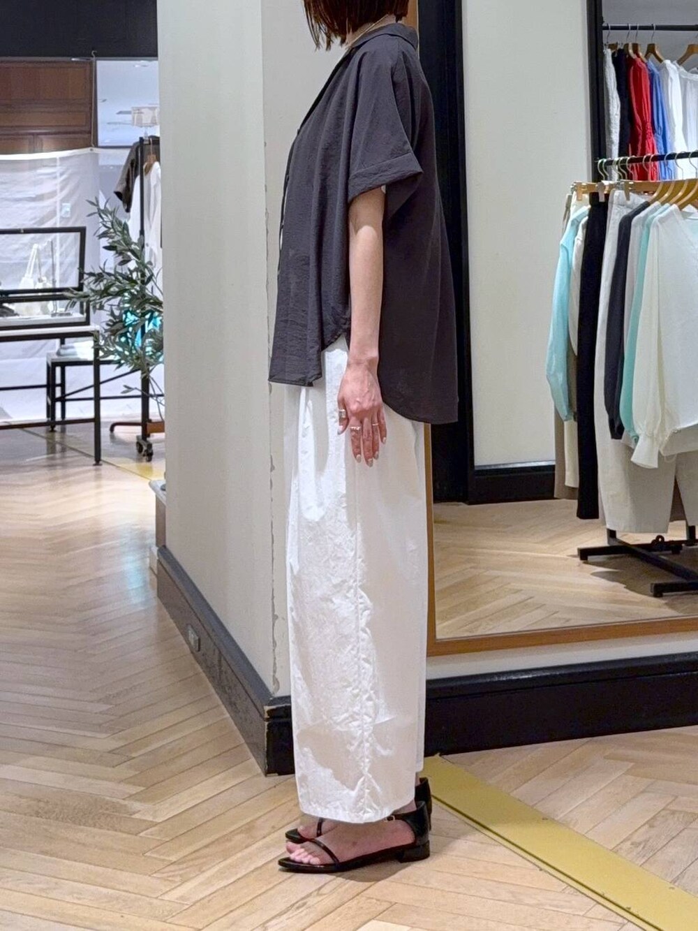 ブラウン系のハンドバッグ、グレー系のシャツ/ブラウス、ホワイト系のTシャツ/カットソーを着用したレディースの春コーディネートの2枚目の写真