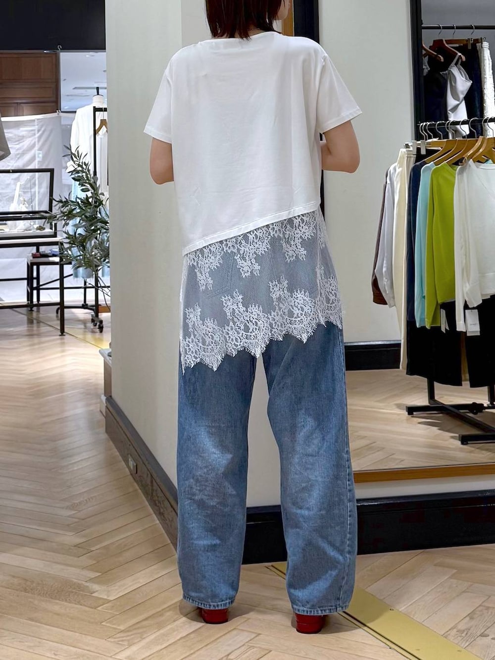 ブルー系のデニムパンツ、レッド系のサンダル、ホワイト系のTシャツ/カットソーを着用したレディースの夏コーディネートの3枚目の写真
