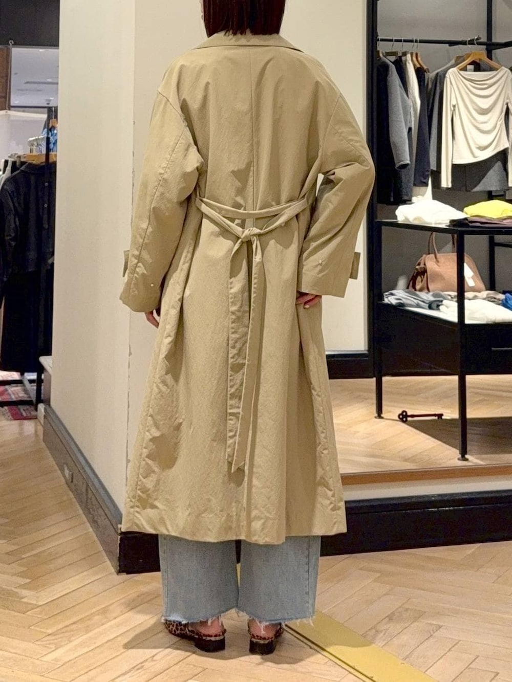 ブルー系のデニムパンツ、ブラウン系のショルダーバッグ、ベージュ系のその他アウターを着用したレディースの春コーディネートの5枚目の写真