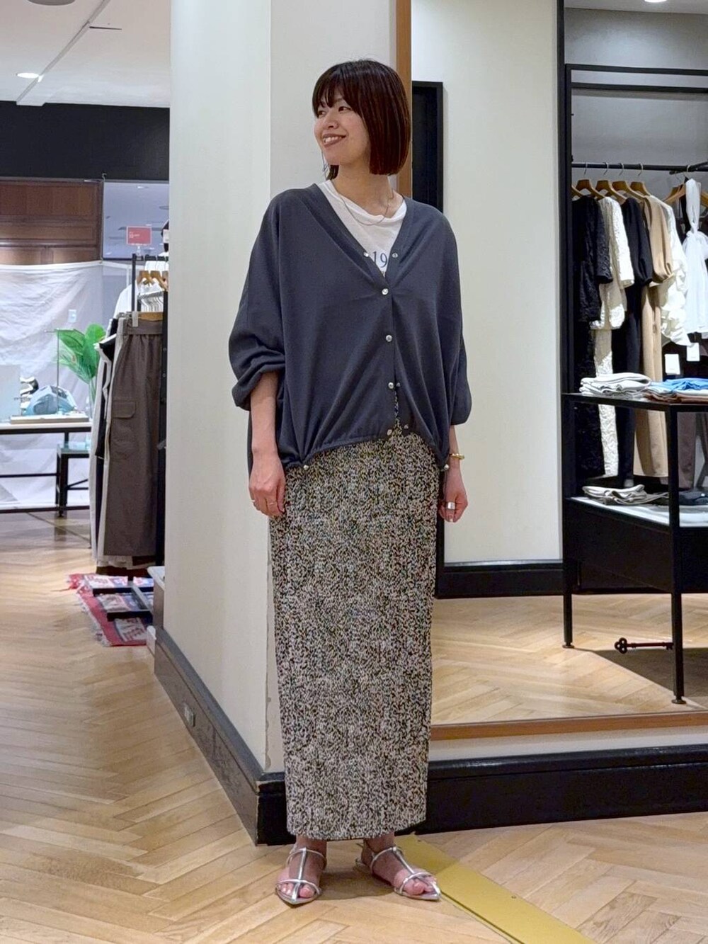 グレー系のカーディガン/ボレロ、シルバー系のサンダル、ベージュ系のスカートを着用したレディースの夏コーディネートの6枚目の写真