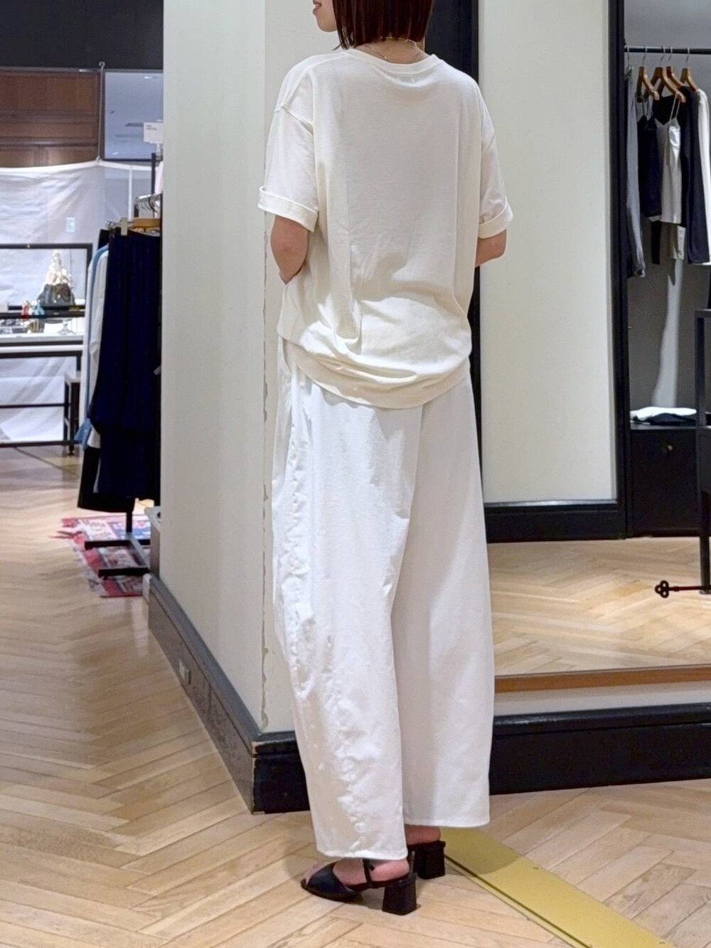ブラック系のショルダーバッグ、ブラック系のサンダル、ホワイト系のTシャツ/カットソーを着用したレディースの春コーディネートの4枚目の写真