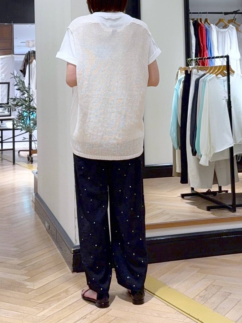 ホワイト系のニット/セーター、ホワイト系のTシャツ/カットソー、ブラック系のサンダルを着用したレディースの春コーディネートの4枚目の写真