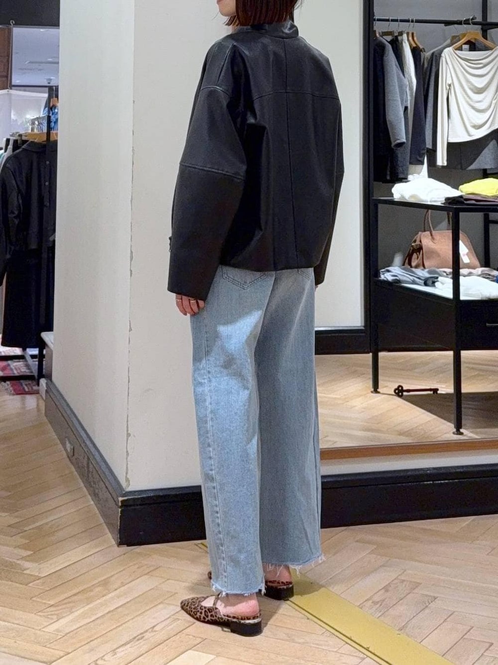 ブルー系のデニムパンツ、ブラック系のブルゾン、ブラウン系のパンプスを着用したレディースの春コーディネートの4枚目の写真