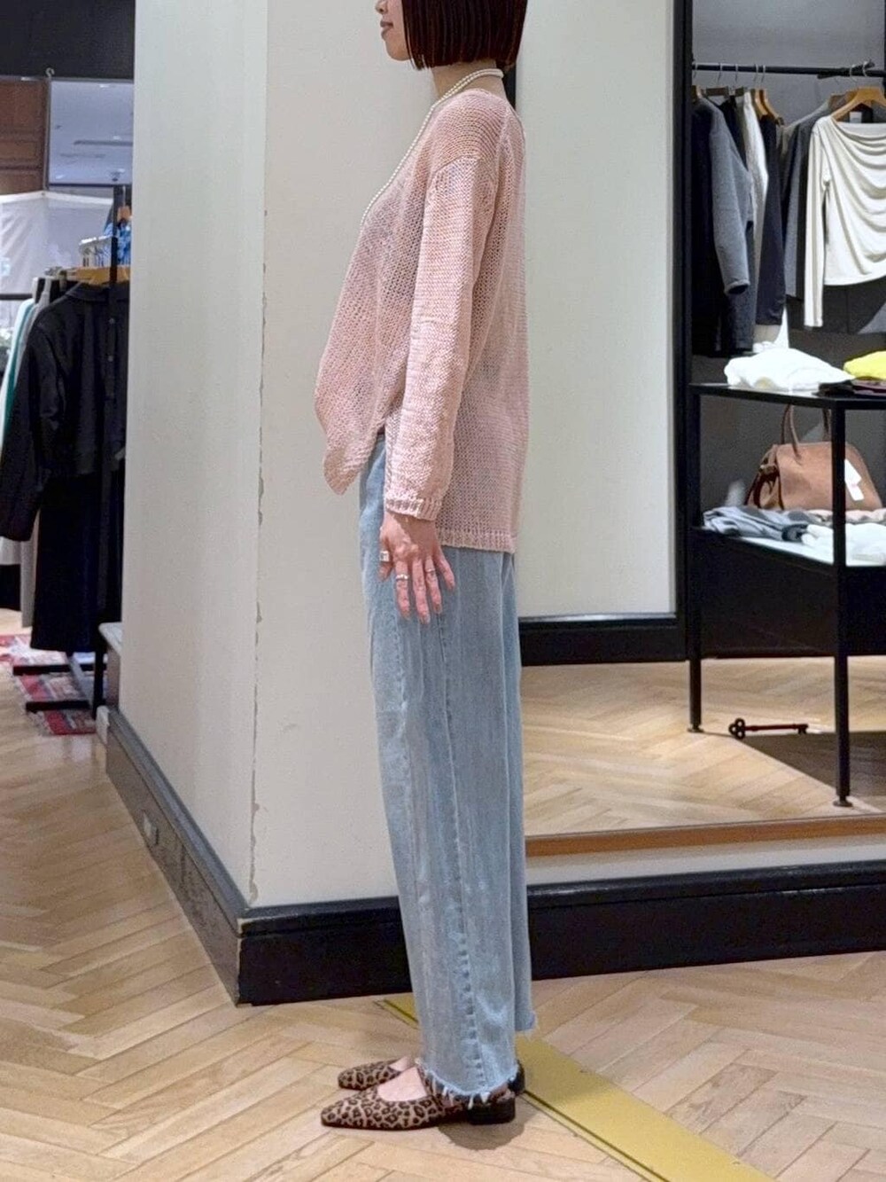 ブルー系のデニムパンツ、ブラウン系のパンプス、ピンク系のニット/セーターを着用したレディースの春コーディネートの2枚目の写真