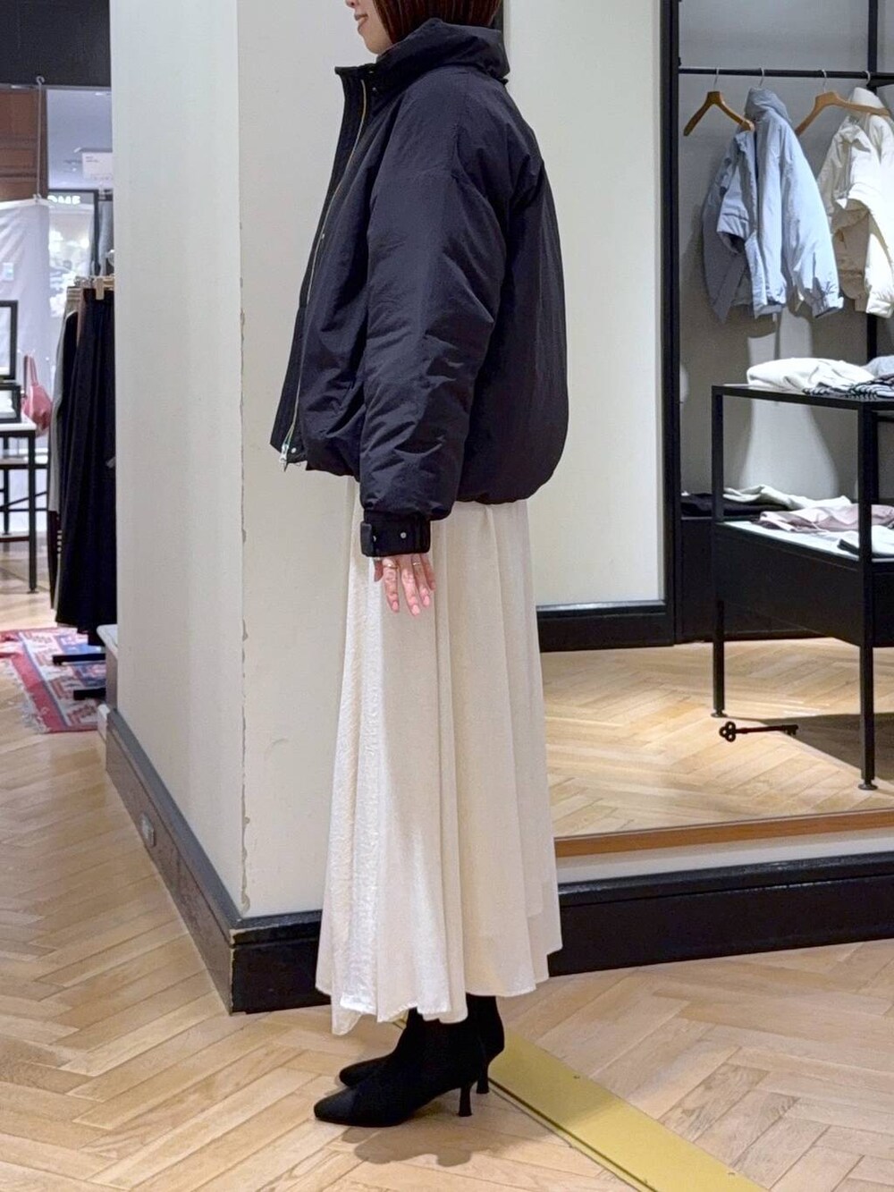 ブラウン系のニット/セーター、ブラック系のブルゾン、ブラック系のブーツを着用したレディースの秋コーディネートの3枚目の写真