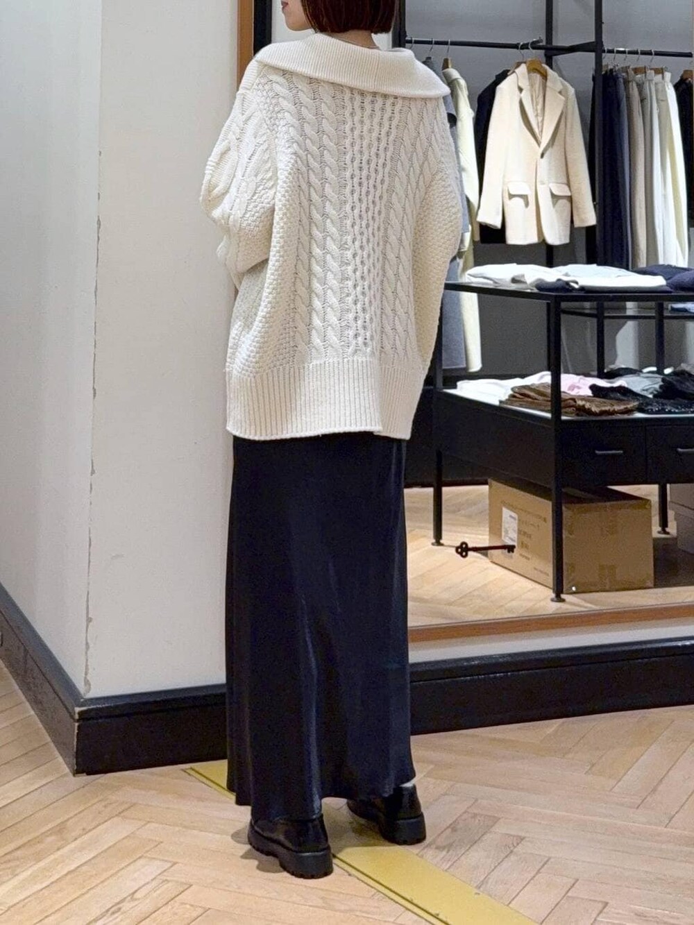 ブルー系のスカート、ベージュ系のショルダーバッグ、ホワイト系のニット/セーターを着用したレディースの冬コーディネートの4枚目の写真