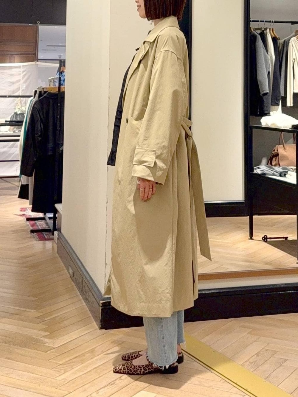 ブルー系のデニムパンツ、ブラウン系のショルダーバッグ、ベージュ系のその他アウターを着用したレディースの春コーディネートの3枚目の写真