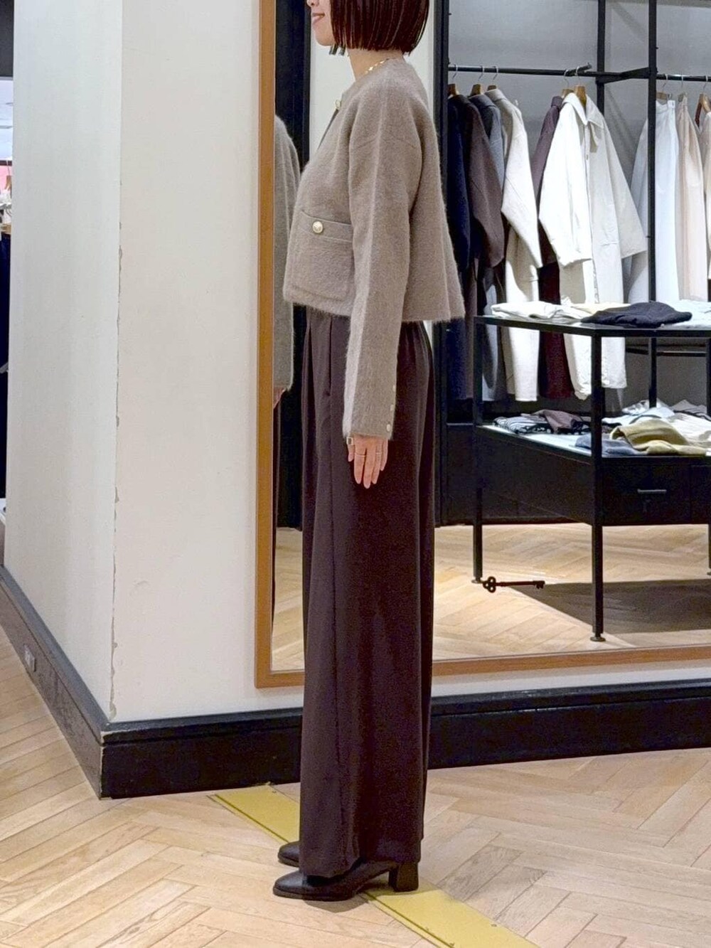 ブラウン系のブーツ、イエロー系のカーディガン/ボレロ、ブラウン系のスラックスを着用したレディースの秋コーディネートの2枚目の写真