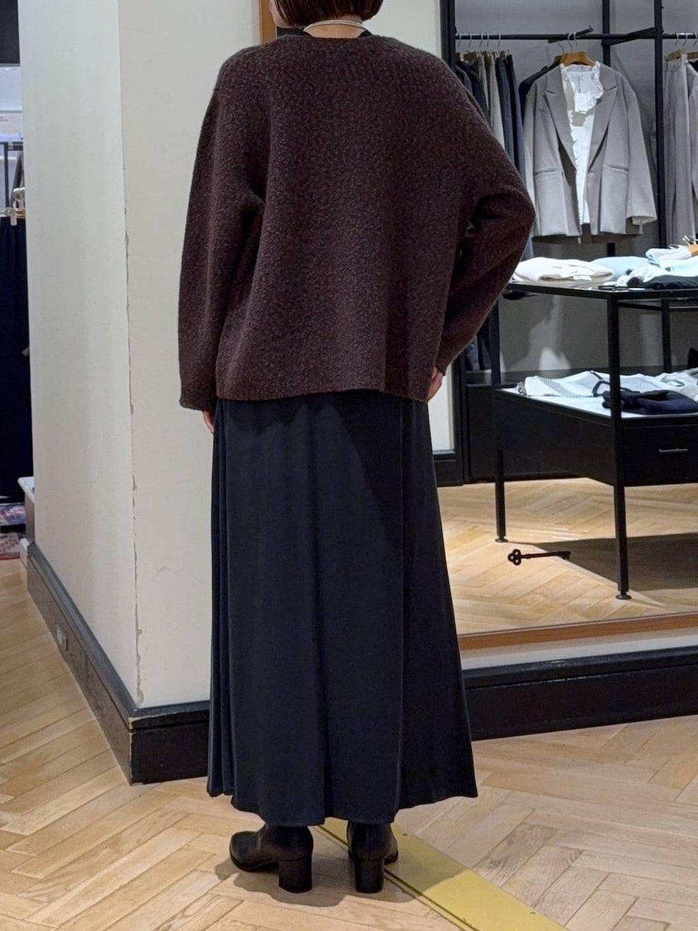 ブラック系のブーツ、ブラウン系のカーディガン/ボレロ、ブラック系のスカートを着用したレディースの秋コーディネートの5枚目の写真